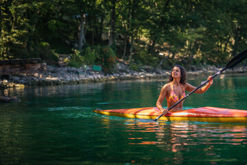 Lady paddling the kayak at the calm lake