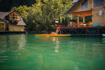 Obraz premium Lady paddling the kayak at the calm lake