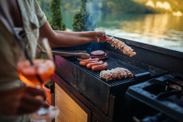 Couple grilling food at barbecue outdoors