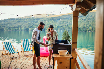 Lovely couple grilling food at barbecue outdoors