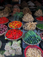 Hanoi, Vietnam, January 30, 2020 - View on a seller in the middle of a large assortment of row loose vegetables and fruits for sale in a street. Short circuit production