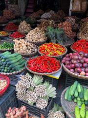 Hanoi, Vietnam, January 30, 2020 - View on a seller in the middle of a large assortment of row loose vegetables and fruits for sale in a street. Short circuit production