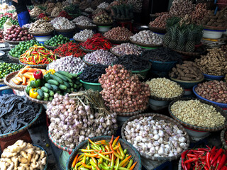 Hanoi, Vietnam, January 30, 2020 - View on a seller in the middle of a large assortment of row loose vegetables and fruits for sale in a street. Short circuit production