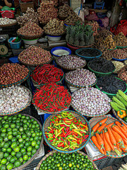 Fresh vegetables for sale at street food market in the old town of Hanoi, Vietnam. Garlic, Lemon, Ananas, Onions, Peper, Red chillies, carots