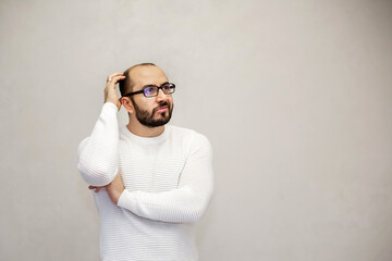 Fototapeta premium Portrait of a young man with his hand on his head. White background.