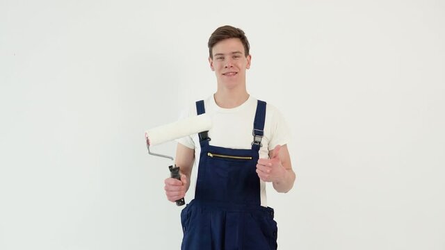 Painter with a roller in his hands looks at the camera