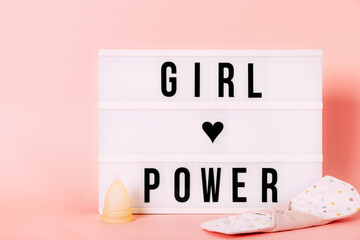 Luminous "girl power" poster with menstrual cup and reusable pad. Feminist themed letters with pink background. Feminism concept.Message concept. Zero waste concept