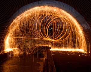 Steel wool was ignited and spun around inside a tunnel with a long exposure. 