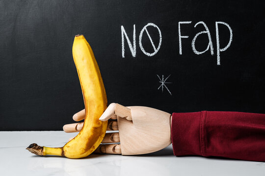 Inscription on chalkboard No fap and a hand holding a banana