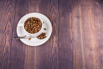 coffee beans in a white cup on a wooden table