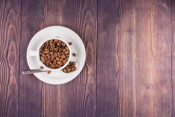 coffee beans in a white cup on a wooden table
