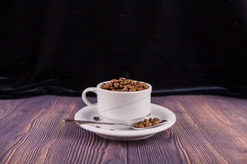 coffee beans in a white cup on a wooden table