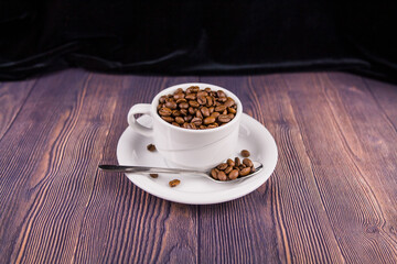 coffee beans in a white cup on a wooden table