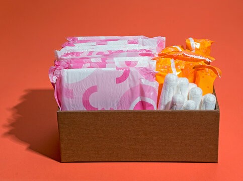 tampons and pads for feminine hygiene in a box on a red background