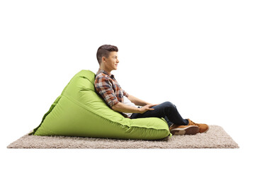 Profile shot of a guy sitting on a green bean bag armchair