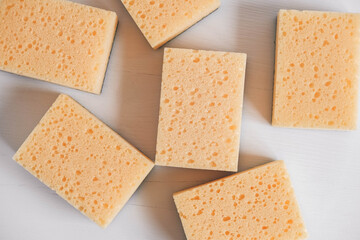 Yellow porous sponges on a white background. Top view. Copy, empty space for text