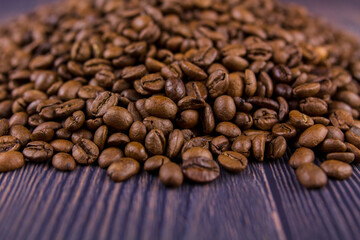 many coffee beans lie on a wooden table
