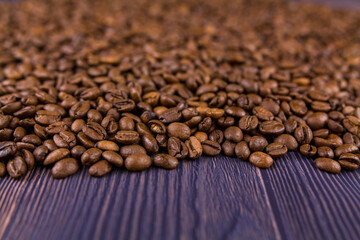 many coffee beans lie on a wooden table
