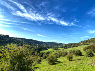 Fototapeta na wymiar Landscape of, Shibden Valley, with trees, bushes, farms, and a blue sky near, Halifax, Yorkshire, UK