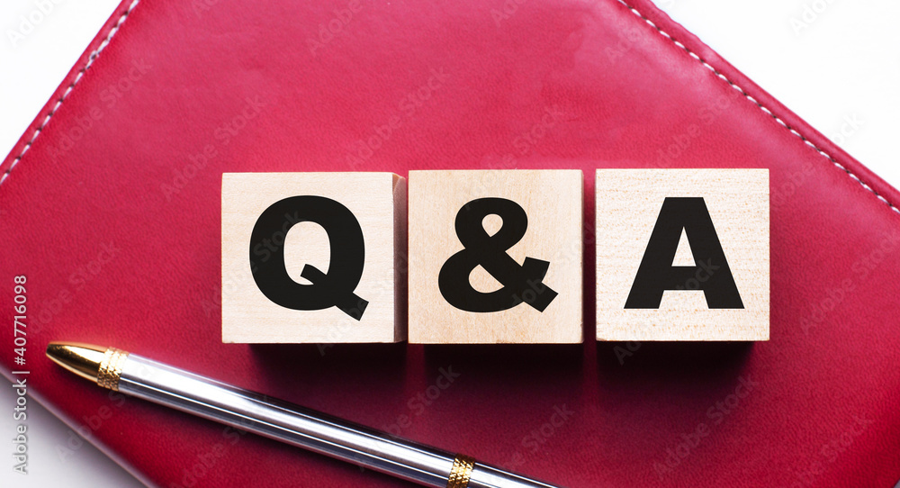 Poster questions and answers q and ais made up of wooden cubes that stand on a burgundy notebook near the p