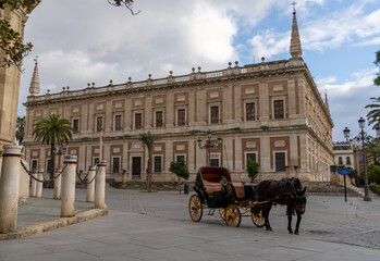 Naklejka premium empty horse-drawn carriage waits for tourists at the Plaza del Triunfo Square for tourists