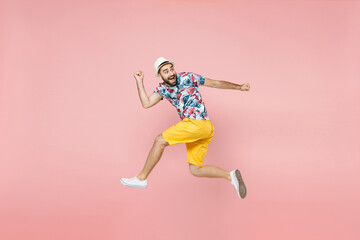 Fototapeta na wymiar Full length side view of amazed young traveler tourist man in summer clothes hat jumping like running isolated on pink background. Passenger traveling abroad on weekend. Air flight journey concept.