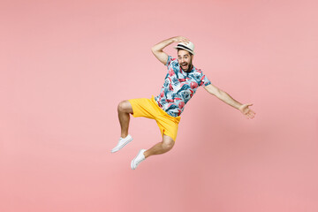 Full length excited young traveler tourist man in summer clothes hat jumping spreading hands...