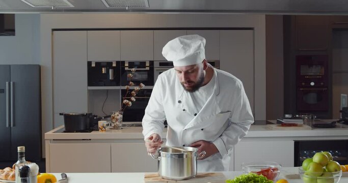 Man chef in uniform tasting disgusting sauce in pan