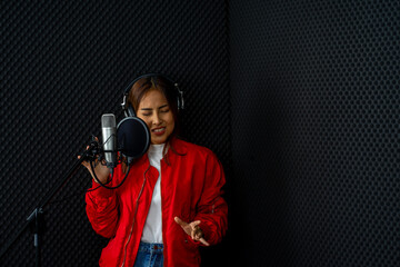 Asian woman singer wearing red shirt rehearsal musical performance in recording studio with microphone 