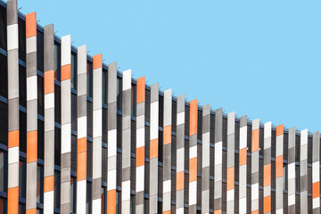 Colorful detail of modern building exterior against blue sky. Abstract geometric architectural background