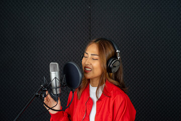 Asian woman singer wearing red shirt rehearsal musical performance in recording studio with microphone 