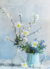 spring  flowers in  vases  on background old  wall