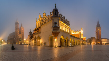 Fototapeta na wymiar Krakow, Poland, main square night panorama with Cloth Hall and St Mary's church in the fog