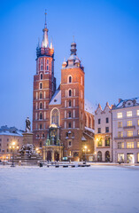 Fototapeta na wymiar St Mary's church on snow covered Main Square in winter Krakow, illuminated in the night