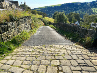 Whiskers Lane, with stone walls, fields and hills in the distance near, Shibden Valley, Halifax, UK