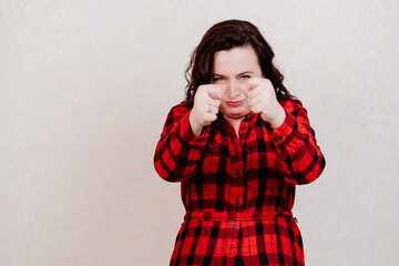 Attractive woman in red dress shows indecent gestures on a white background.