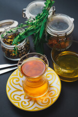 Traditional tea in a glass, tea ceremony with aromatic herbs, mint and honey.