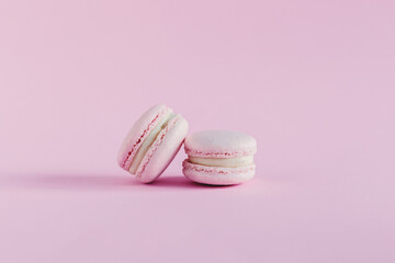 Pink pastel macarons on a pink pastel background.