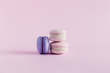 Tasty french macarons on a pink pastel background. Pink and violet macarons.