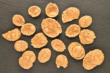 Delicious multi-grain flakes on a slate board, close-up, top view.