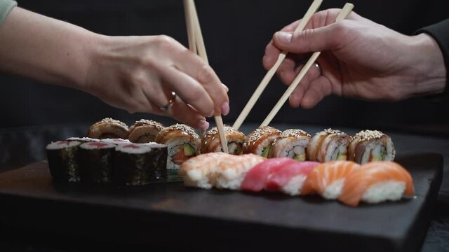 Close-up, couple hands eating sushi food