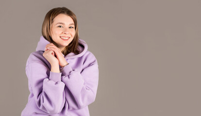 Portrait of beautiful woman with hands near chest isolated on gray studio background