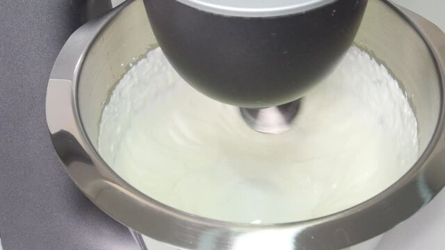 Planetary mixer beats the cream. Process of whipping cream.