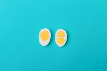 Two halves of a chicken egg on a blue background. Two yolks and one yolk in an egg.