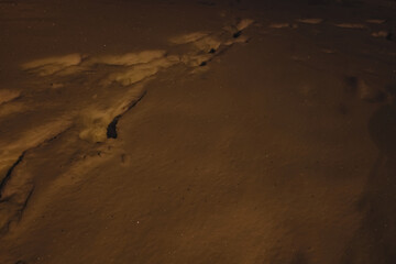 footprint in yellow snow at night