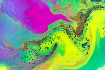 Blue, green and gold glitter on fluorescent liquid ink background.