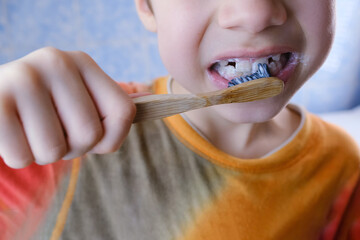boy, kid 6-8 years old diligently brushes teeth and colored children's paste, dental concept, oral...