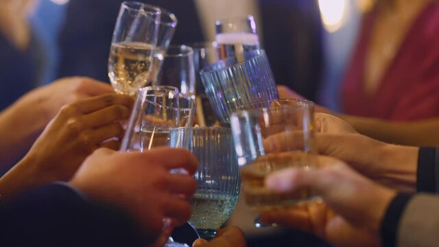 Formally dressed elegant people celebrating corporate event night party toasting glasses with drink together. Corporate party. Business friends.