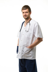 Portrait of a male doctor, hands stuck in pockets, a phonendoscope hangs around his neck, isolated on white background