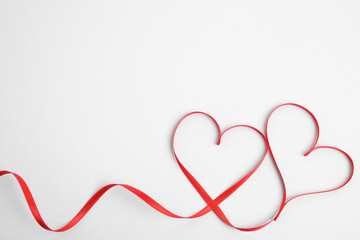 Hearts made of red ribbon on white background, top view. Valentine's day celebration